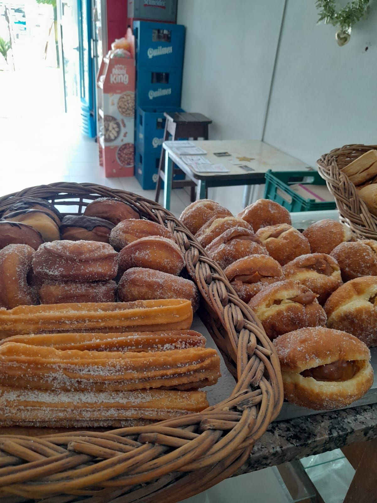 Primer plano de productos horneados en cestas de mimbre sobre un mostrador. 