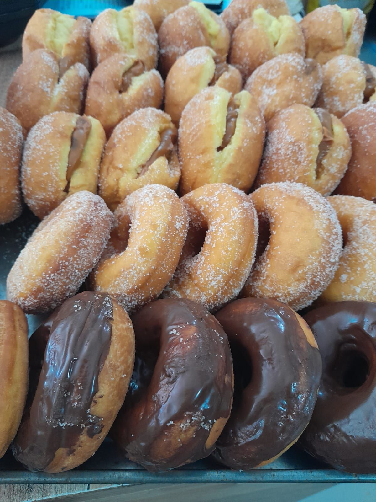 Surtido de donas: rellenas, glaseadas y azucaradas, en expositor.