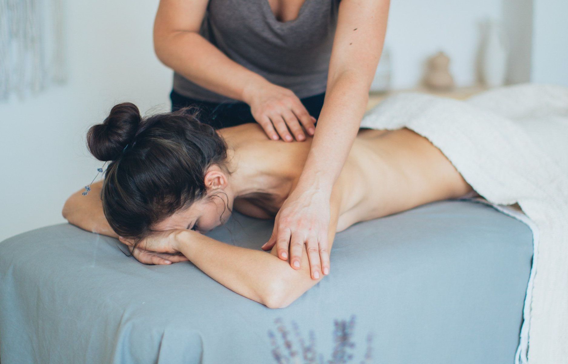 A woman is getting a massage on her back at a clinic. 