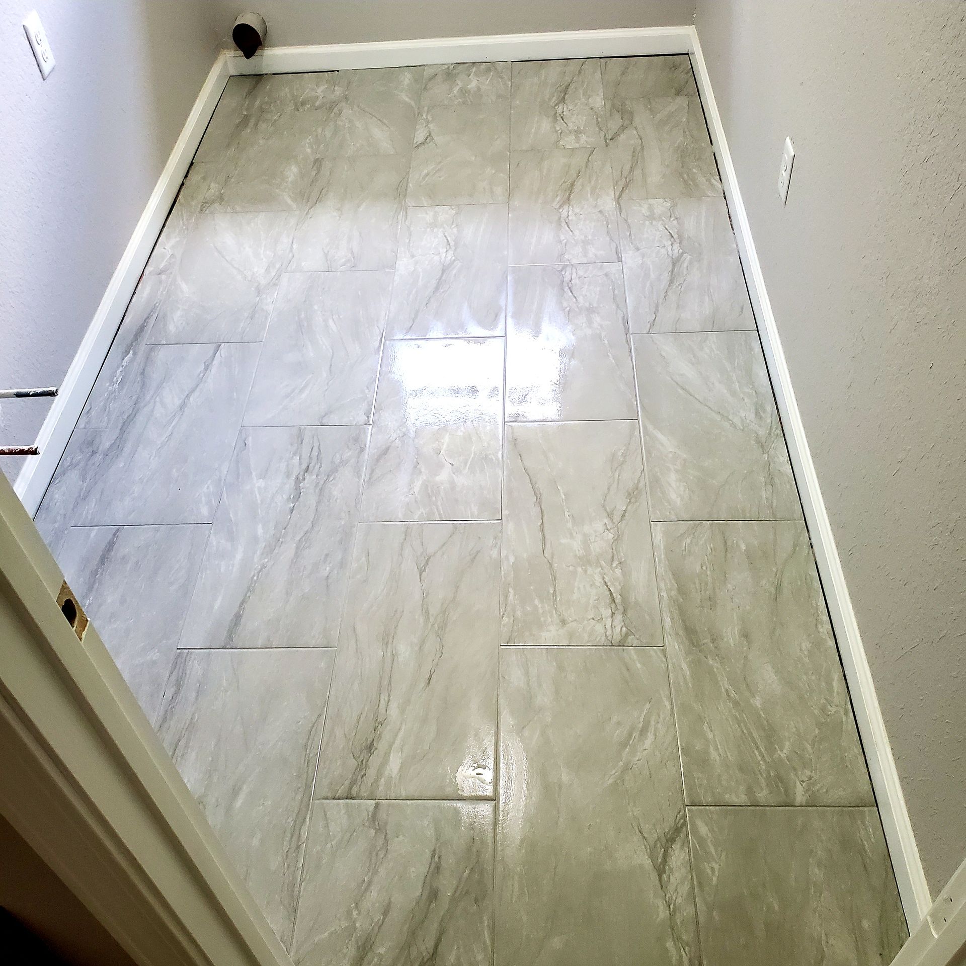A room with a tiled floor and white trim