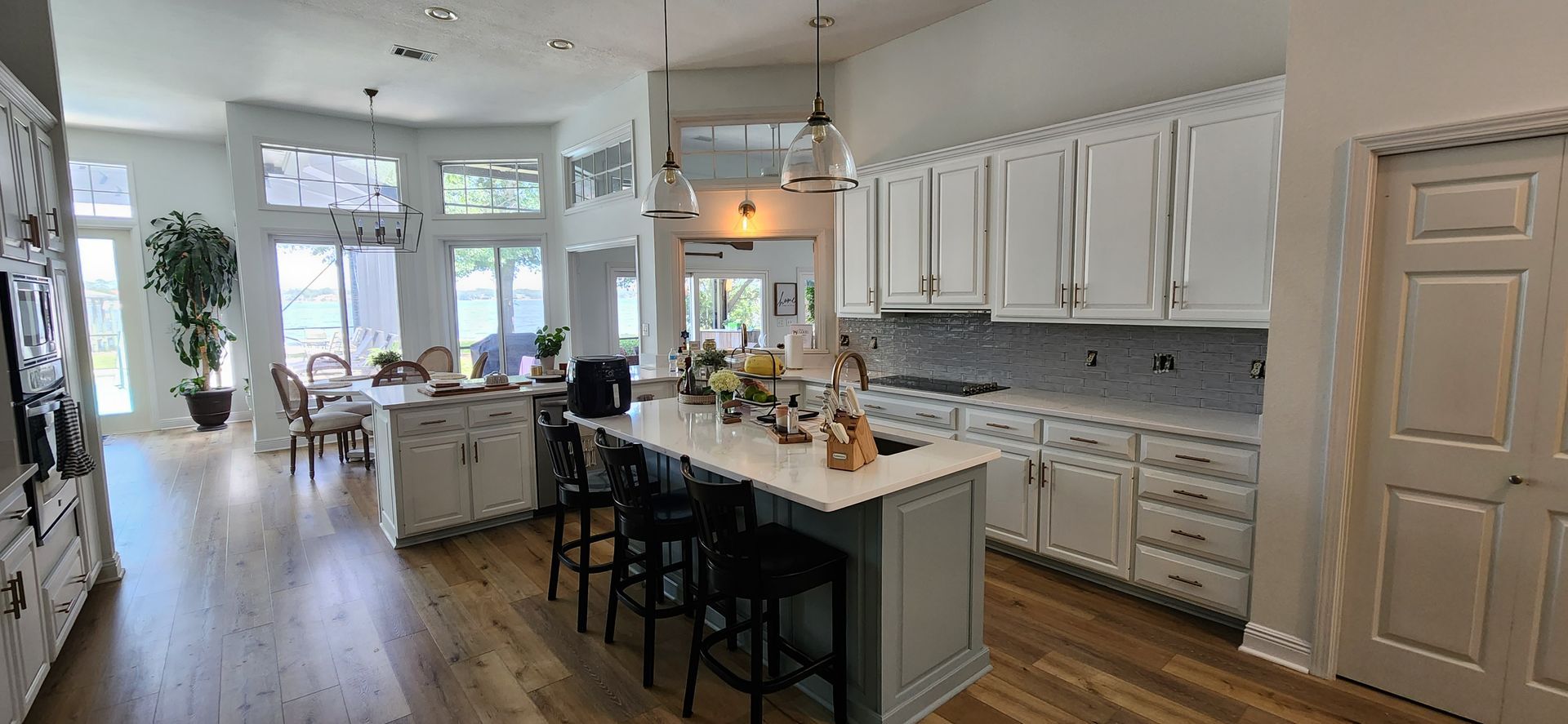 A large kitchen with white cabinets and a large island.