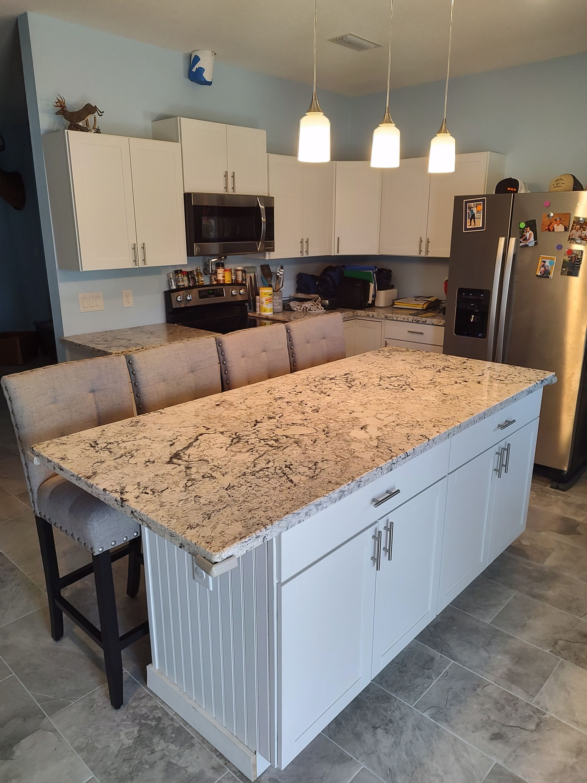 A kitchen with granite counter tops and white cabinets