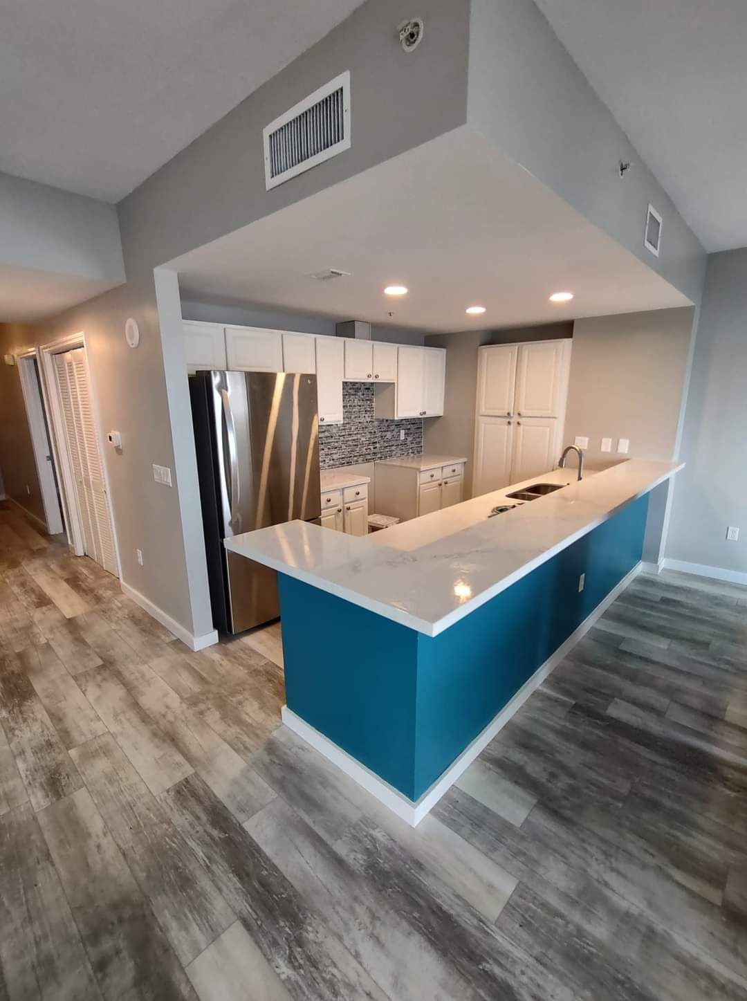 A kitchen with stainless steel appliances and a blue counter top.