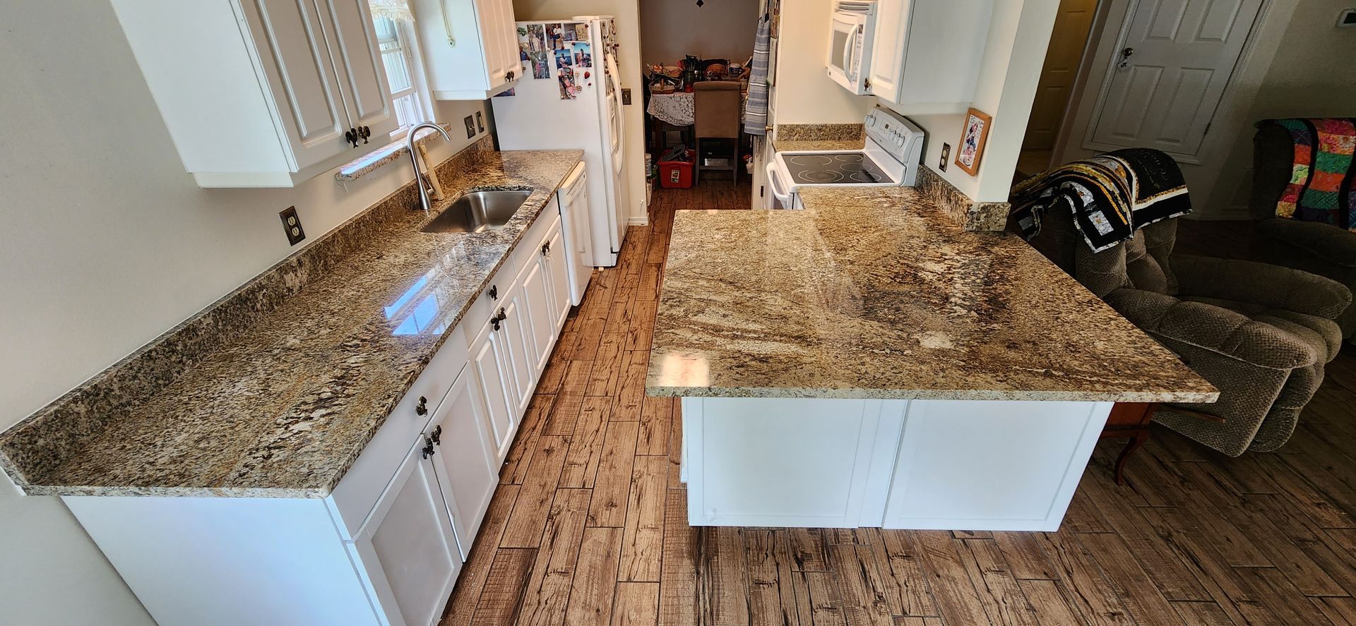 A kitchen with granite counter tops and white cabinets.