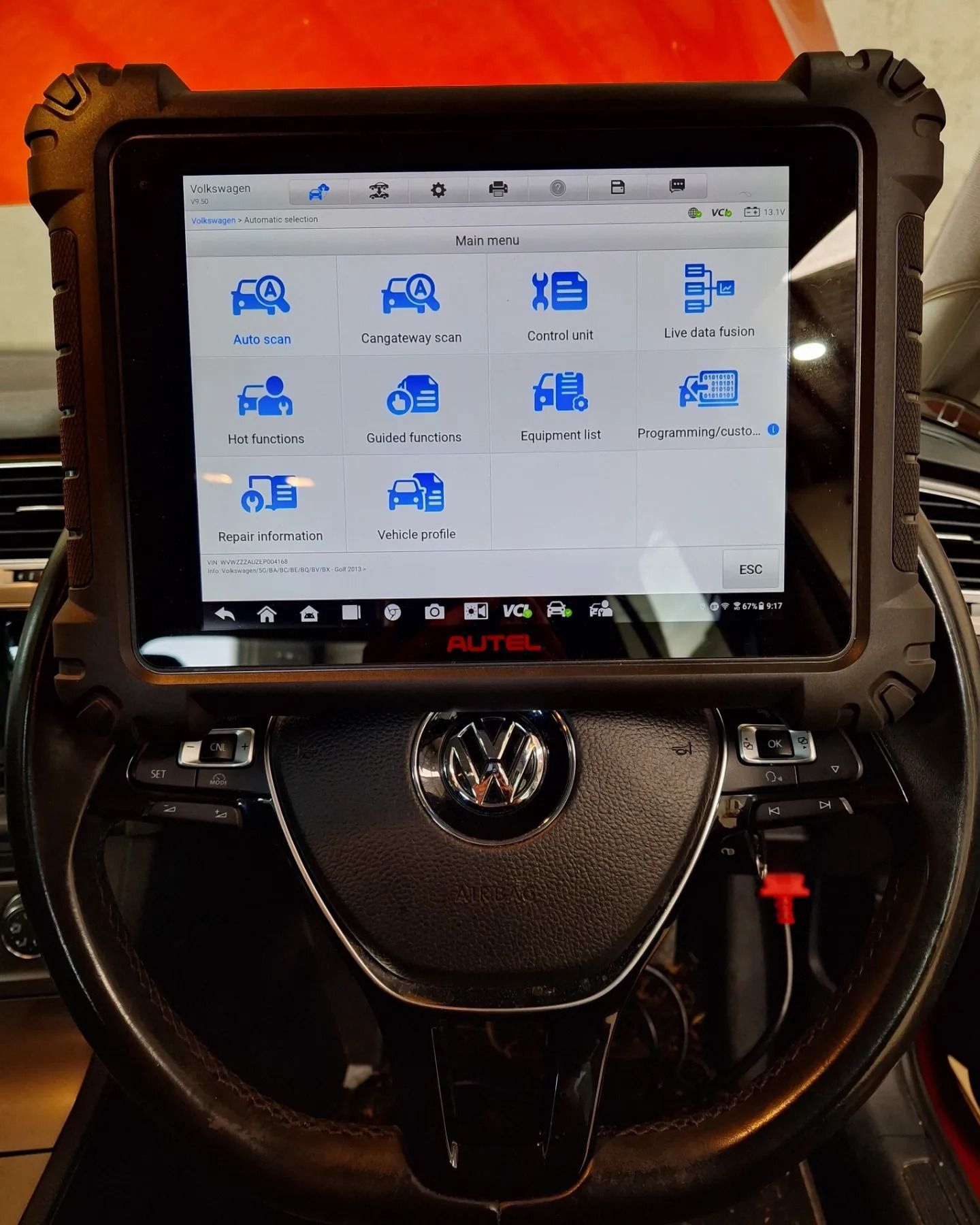 A tablet is sitting on top of a steering wheel.