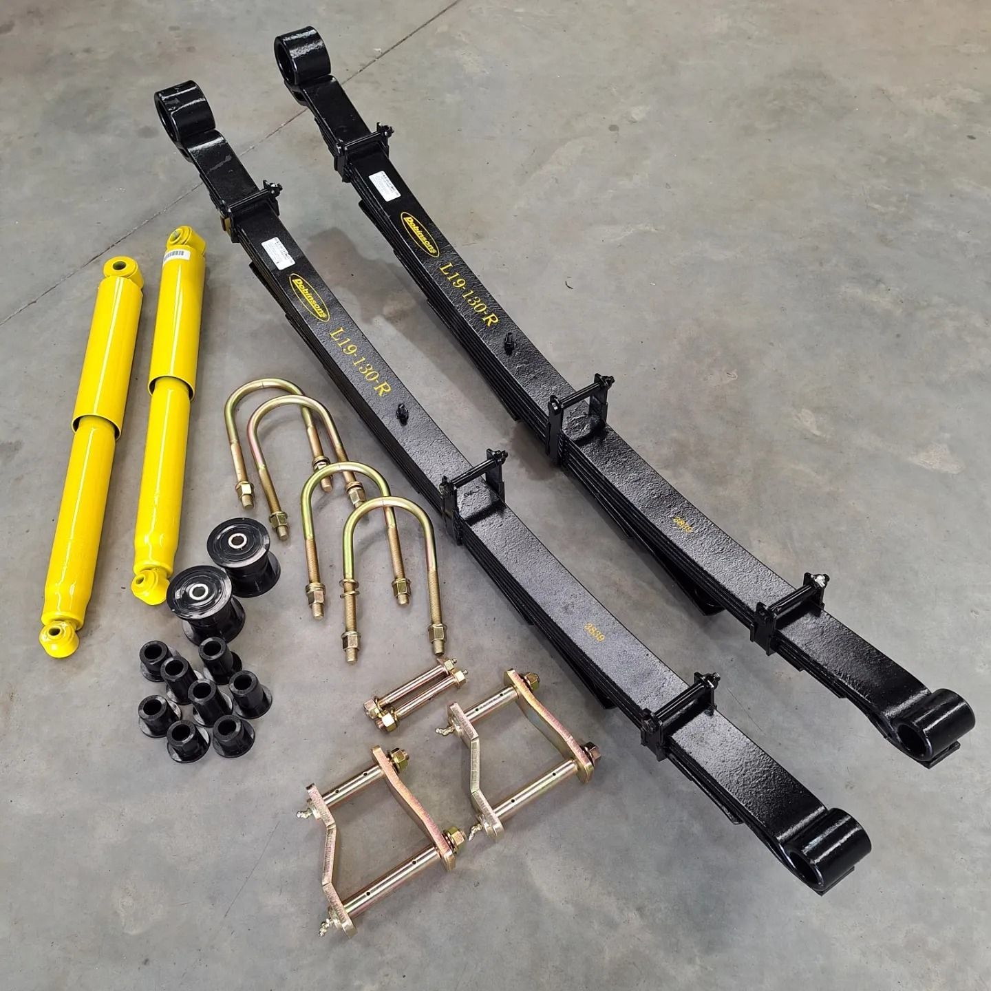 A set of leaf springs and shock absorbers on a concrete surface