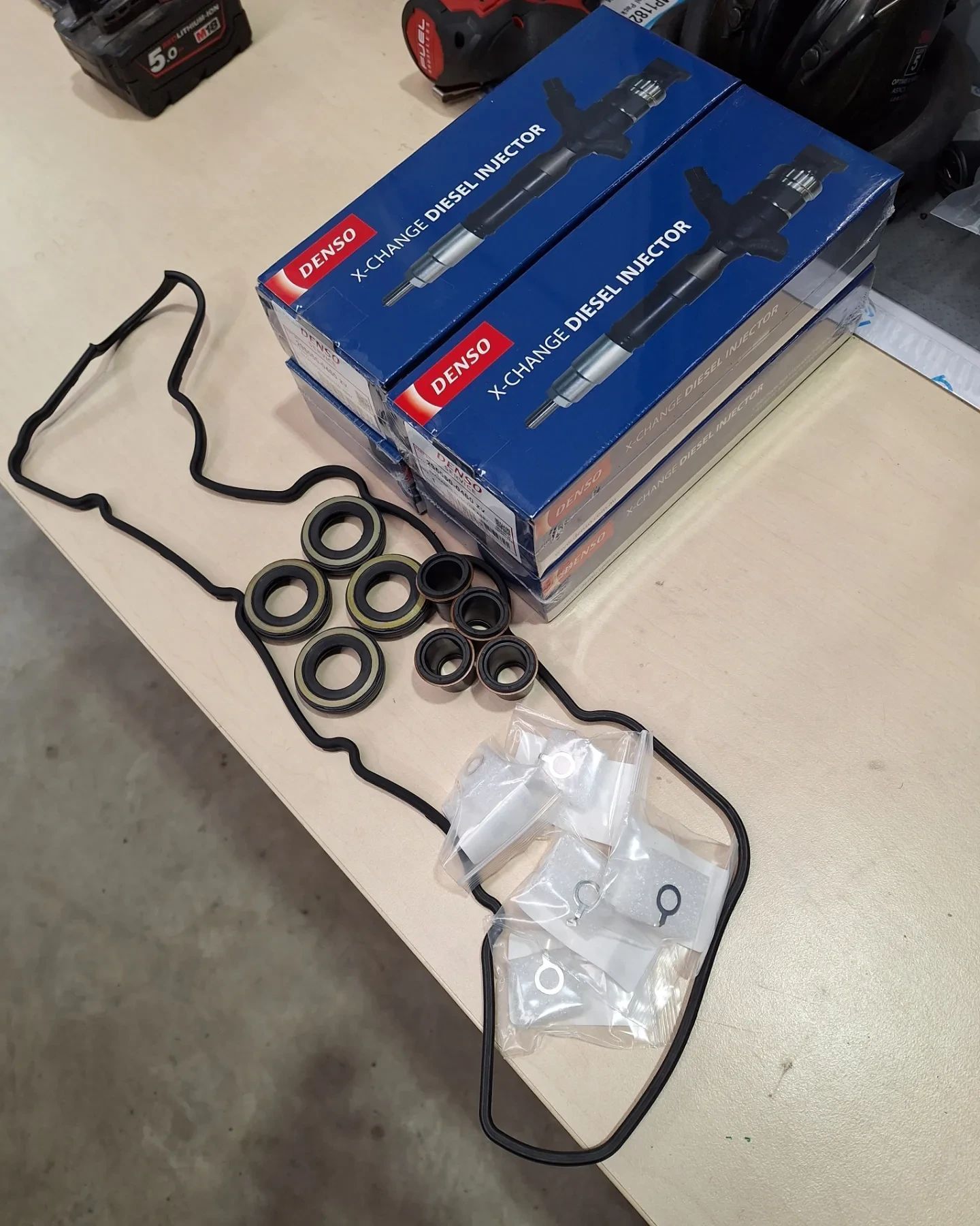 Two boxes of denso spark plugs are sitting on a table.