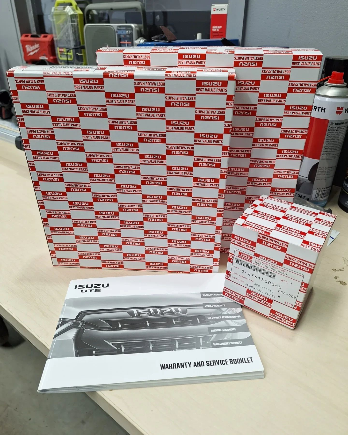 A bmw x3 with its hood up in a garage.