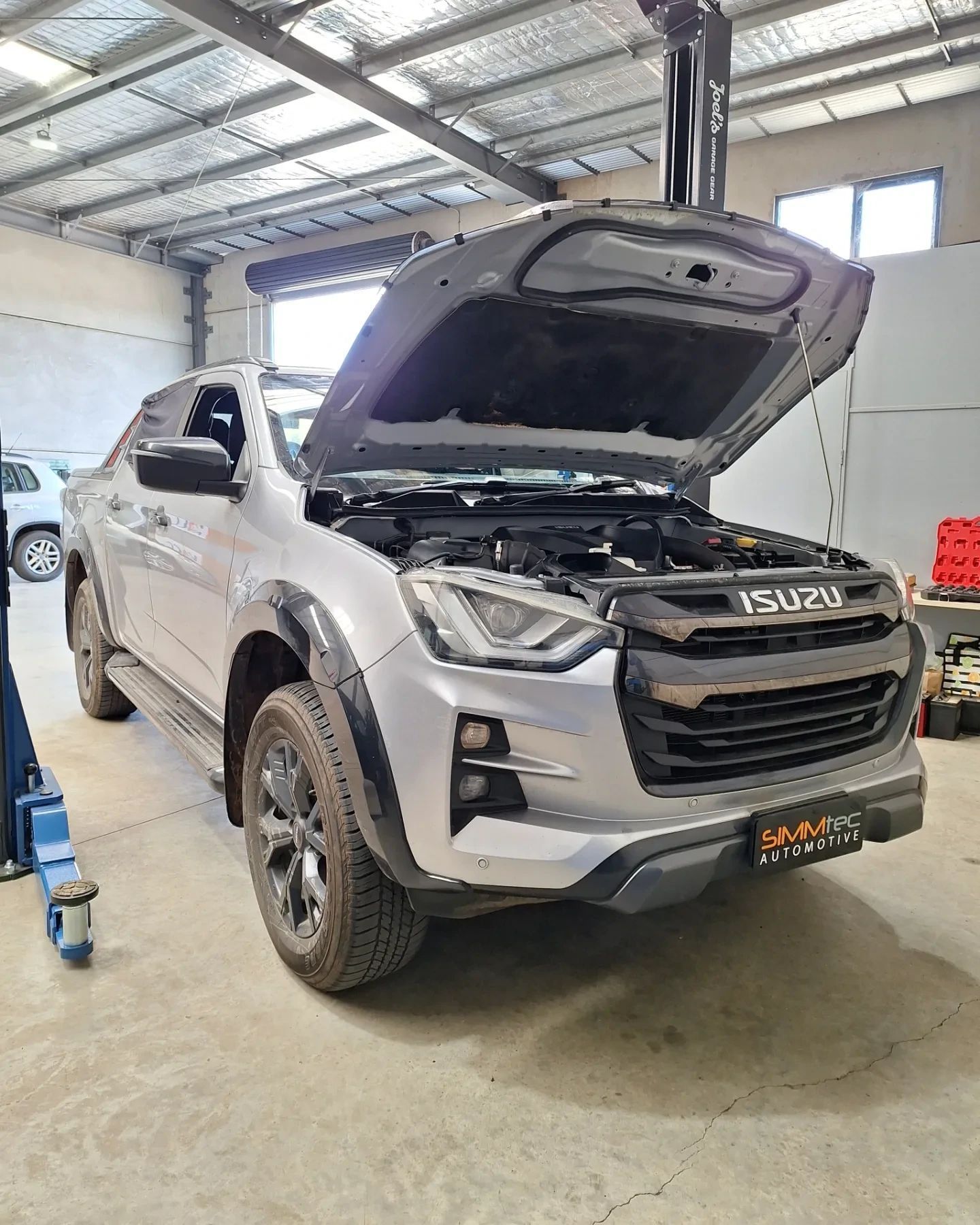 A silver truck with the hood open.