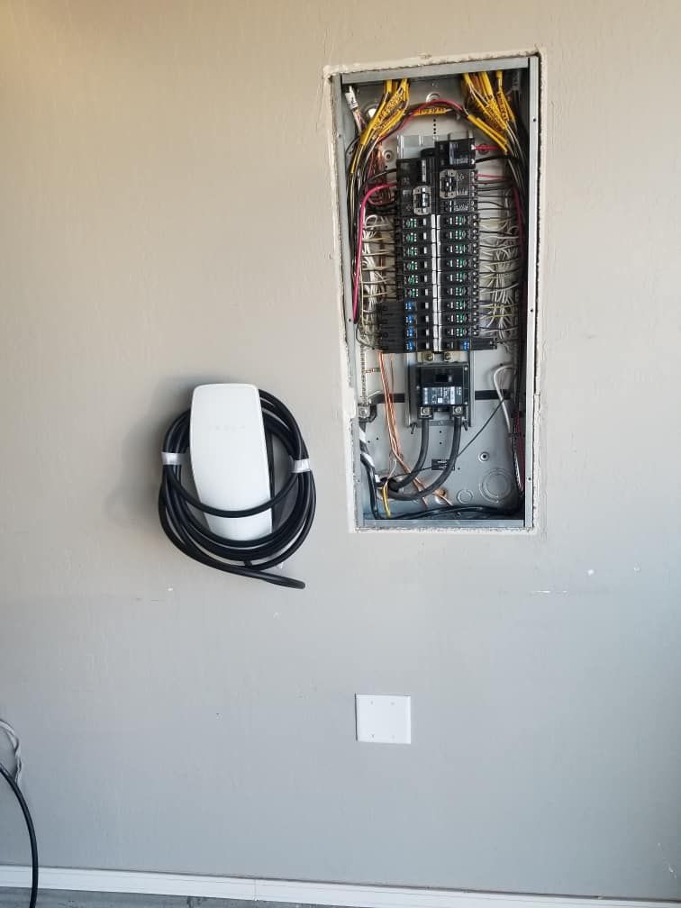 A Tesla Charging Station Is Hanging On A Wall Next To A Electrical Box | Albuquerque, NM | Tesla Electric LLC