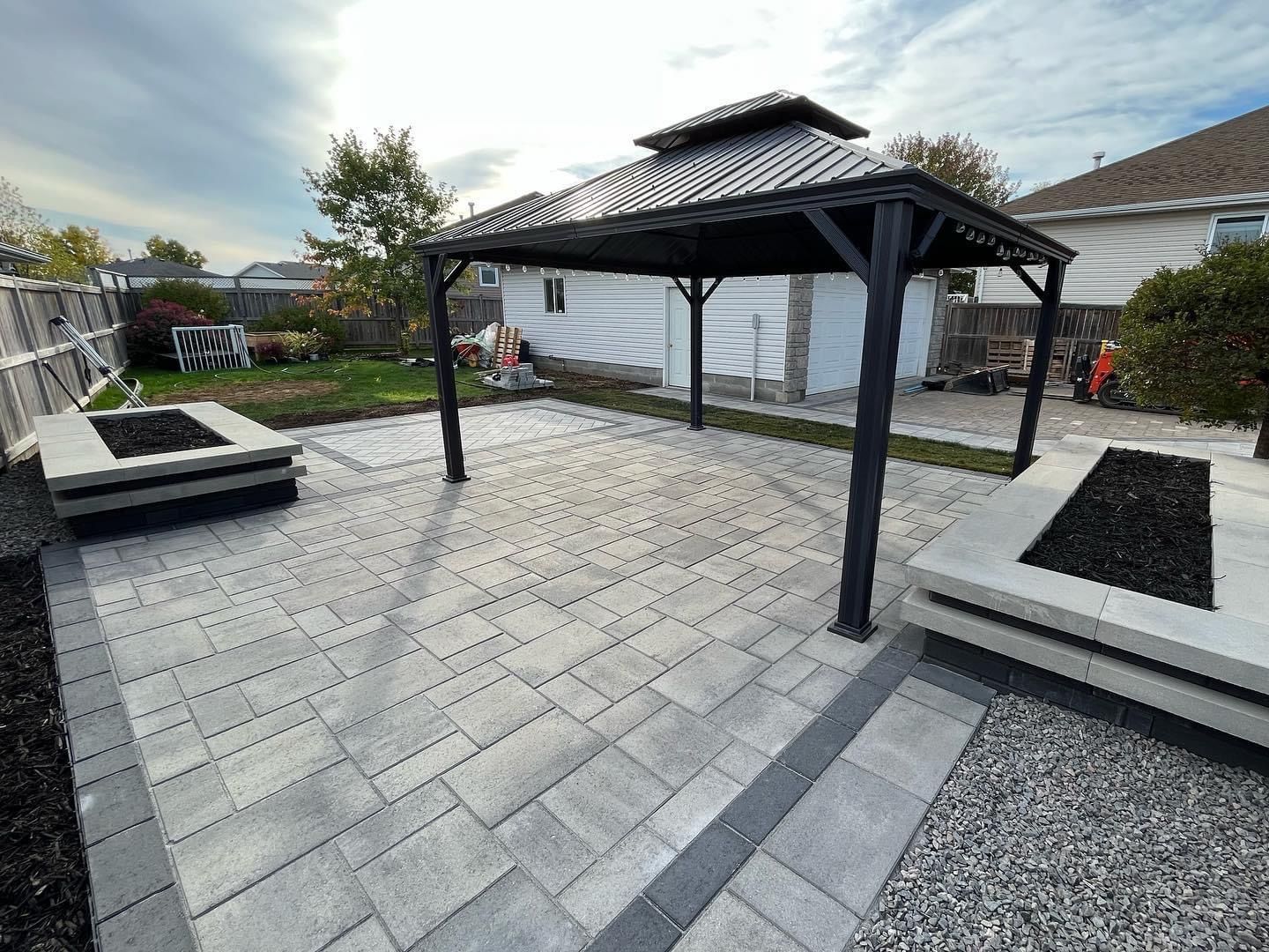 Un patio avec un gazebo et un foyer dans la cour arrière.