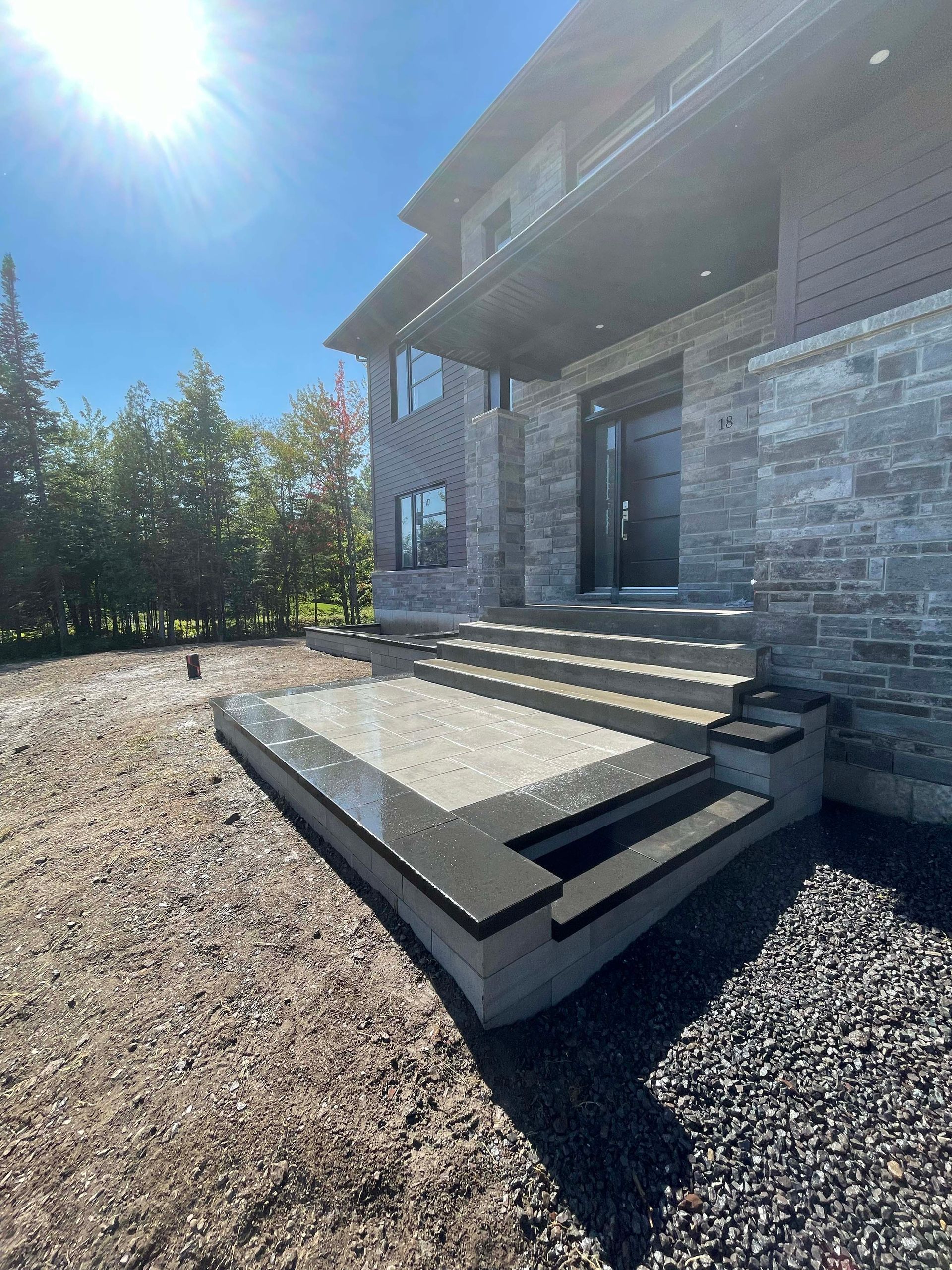 Une grande maison en briques avec des escaliers menant à la porte d'entrée.