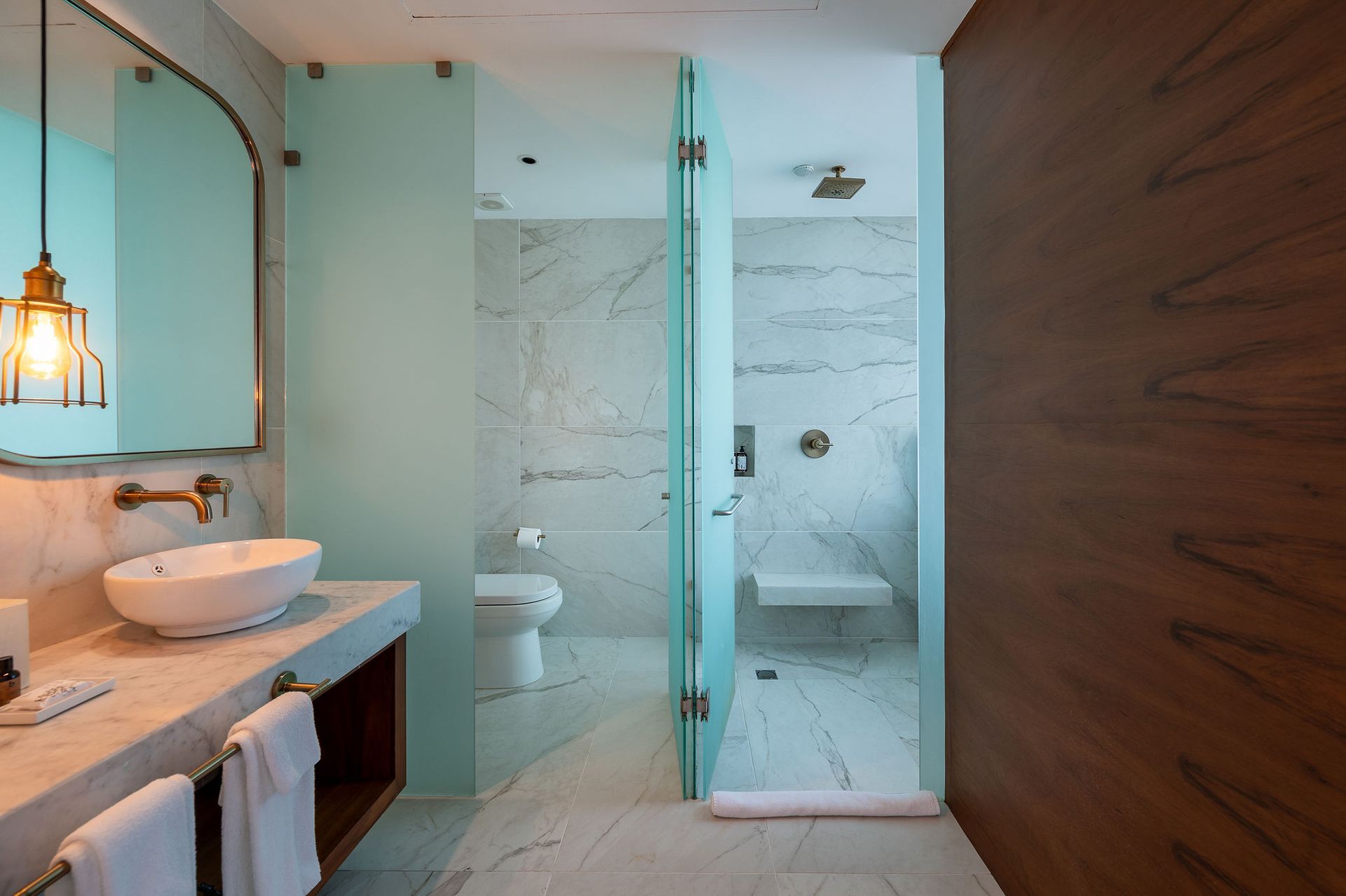 A bathroom with a sink , toilet , shower and mirror.