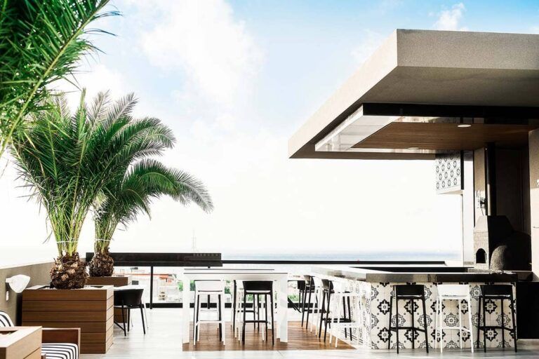 An artist 's impression of a rooftop bar with a view of the ocean.