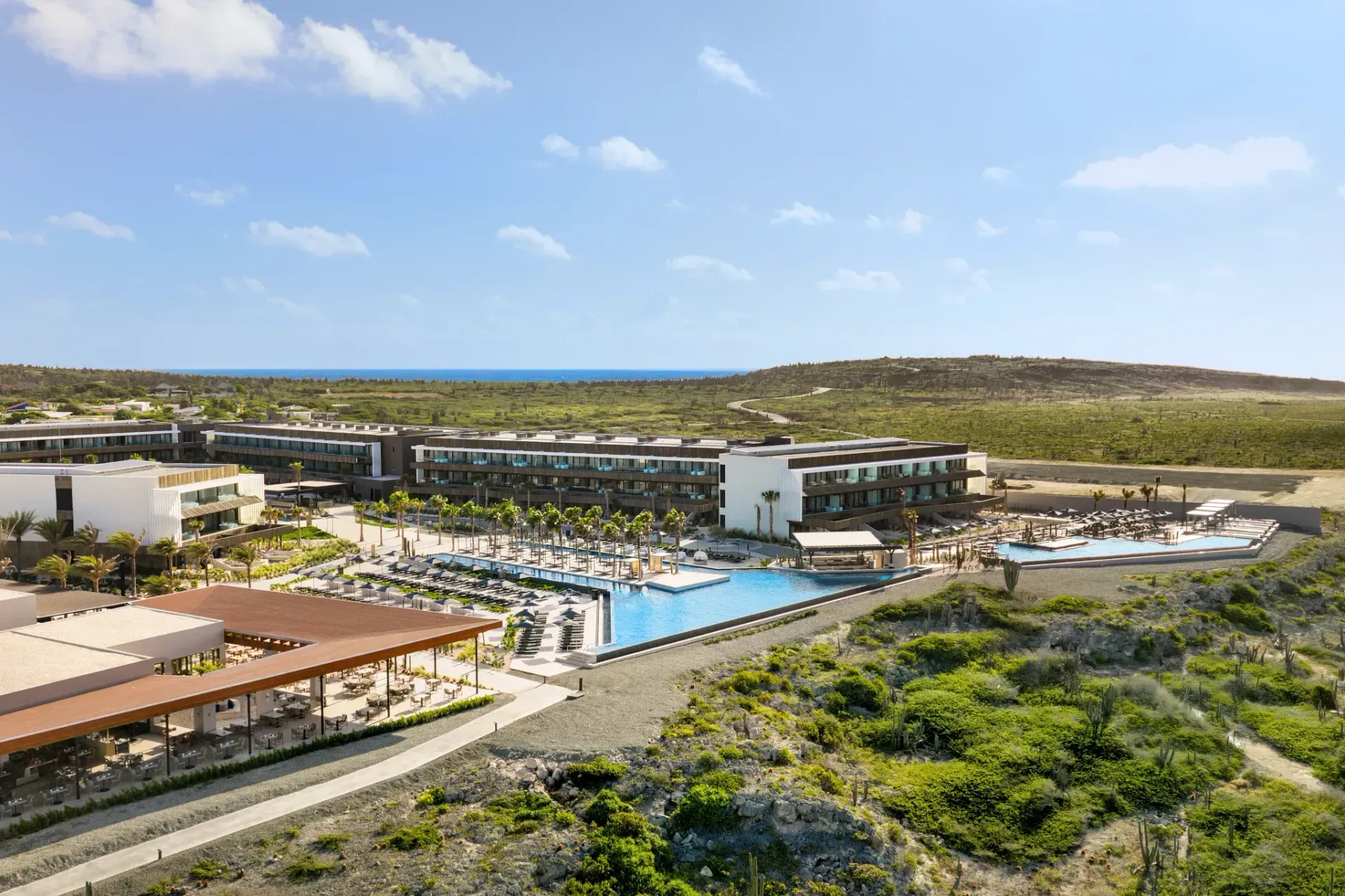 Aerial view of Secrets Baby Beach Resort in Aruba hosting the Ladies Escape 2027 retreat