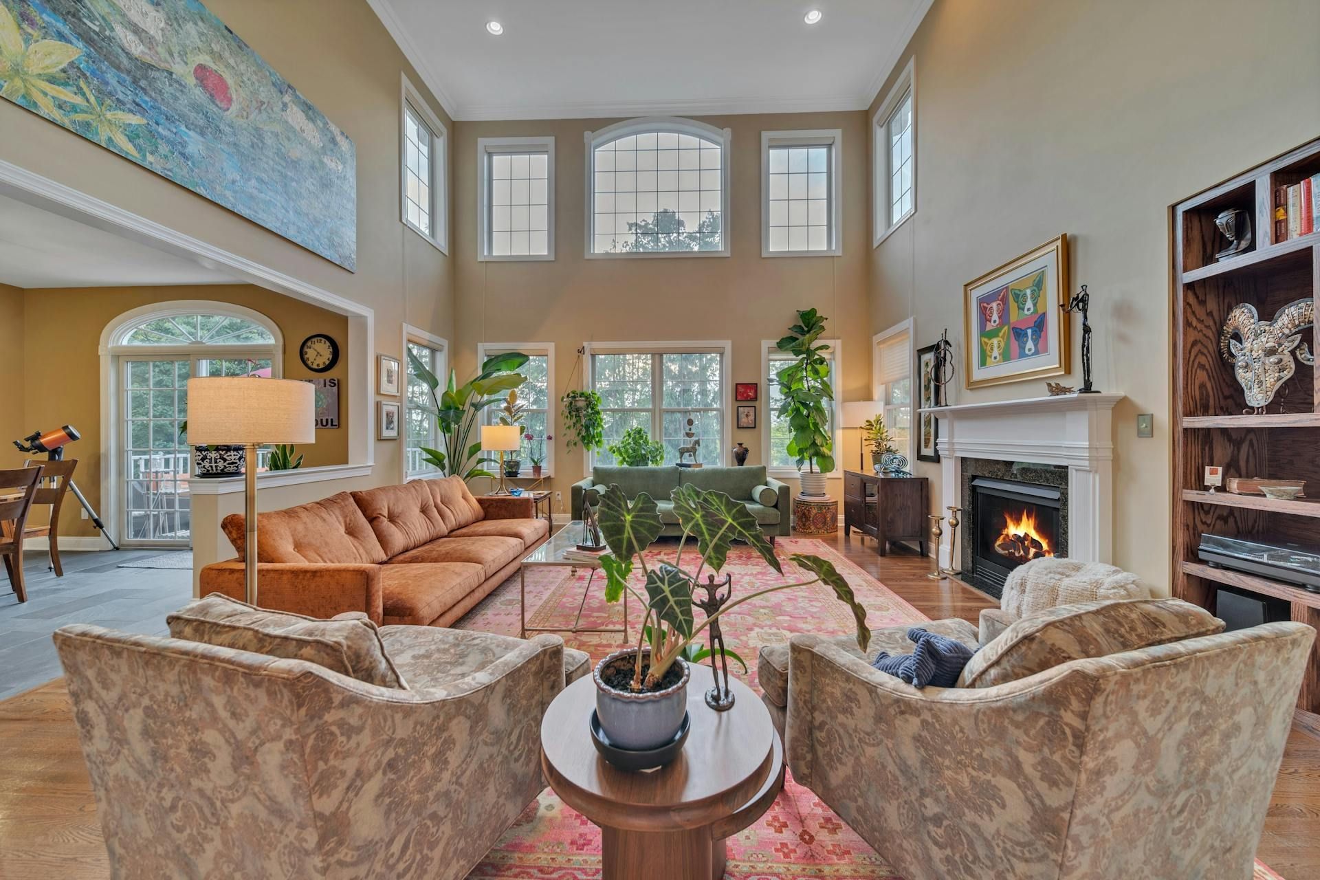 A living room with a couch , chairs , ottoman and a mirror