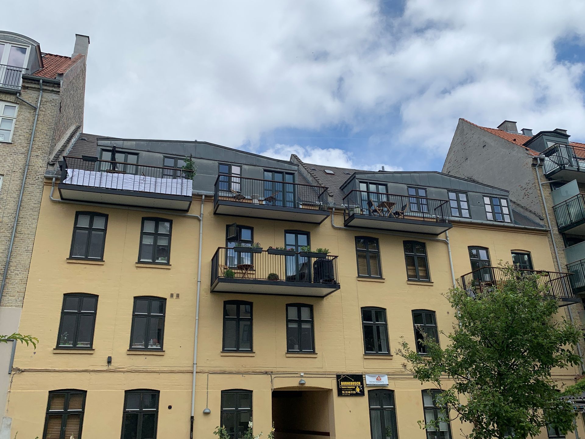 En gul bygning med altaner og et skilt på taget, hvor der står 'jeg elsker dig'