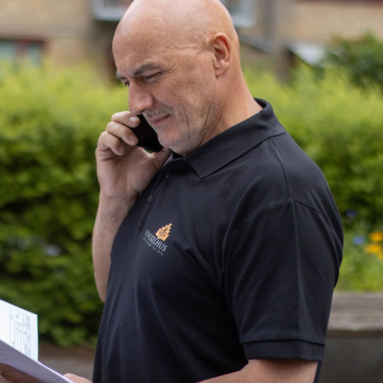 En mand i sort skjorte taler i mobiltelefon