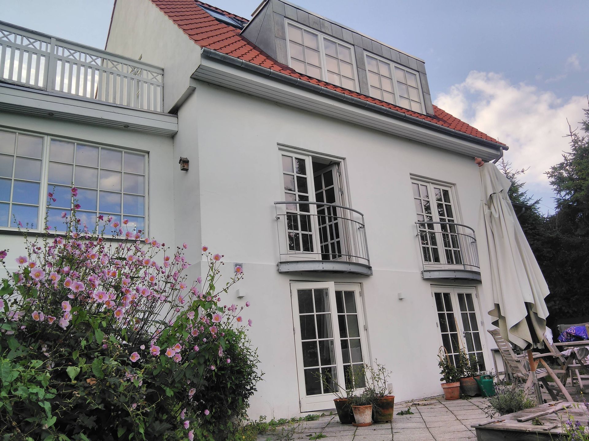 Et stort hvidt hus med rødt tag og mange vinduer