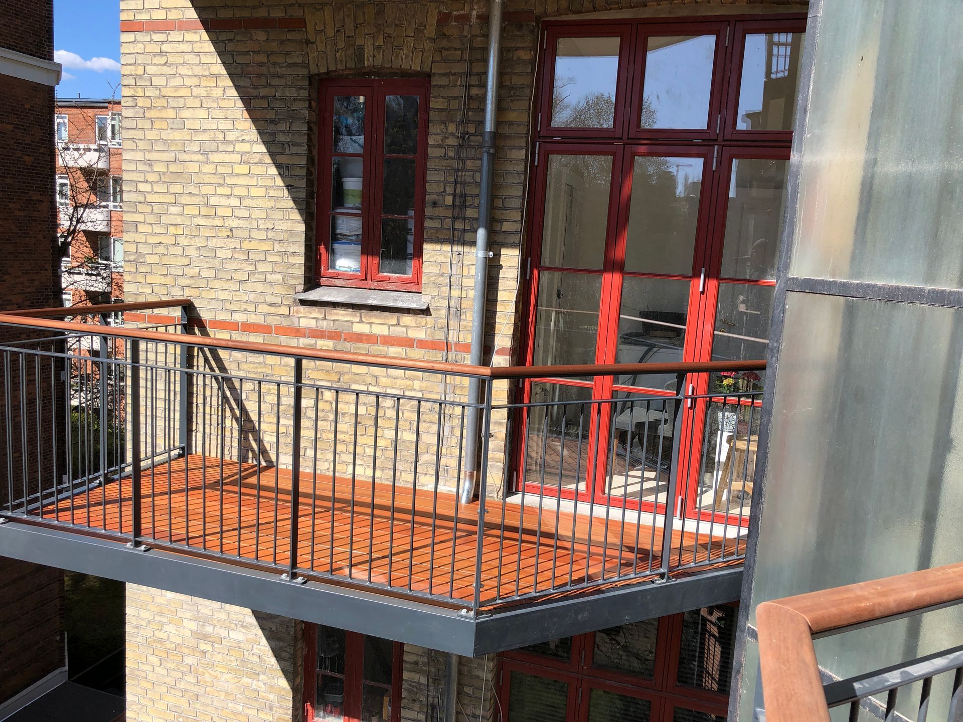 En balkon med en murstensbygning i baggrunden