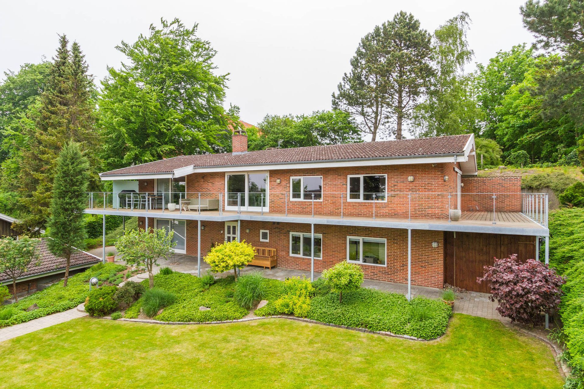 Et stort murstenshus med en stor græsplæne foran