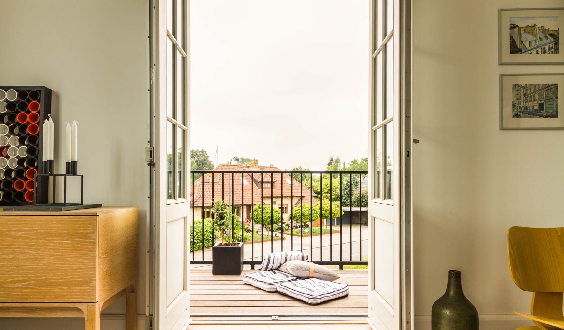 En stue med balkon med udsigt til et hus.