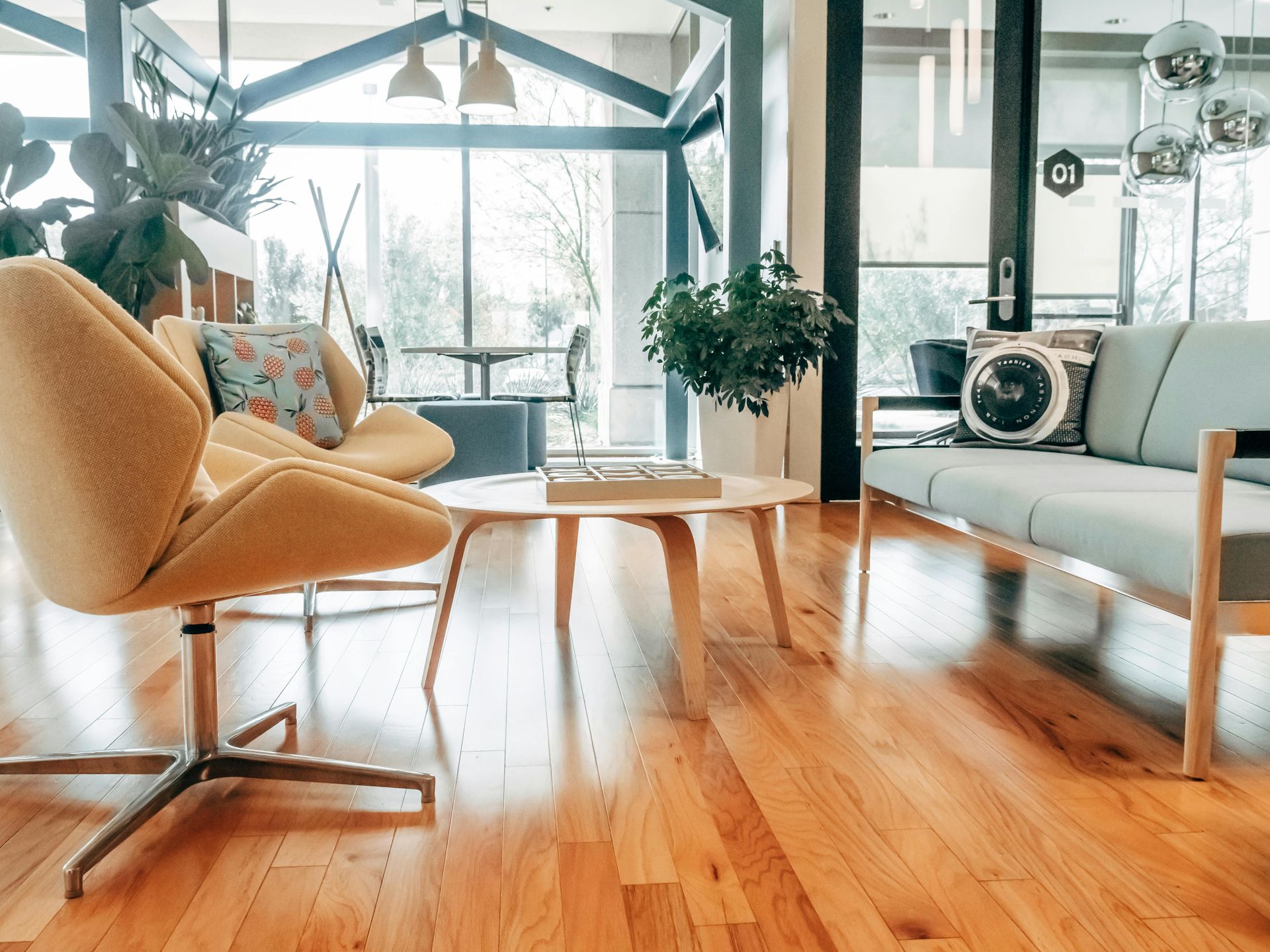 A living room with hardwood floors , a couch , chairs , and a table.