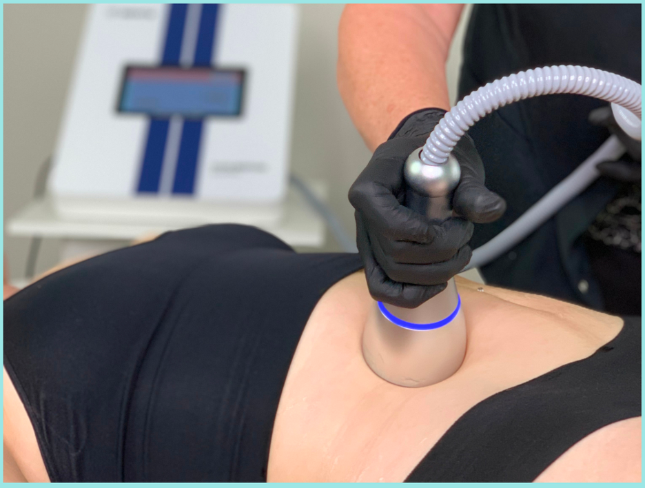 A person lying under a blue Celluma LED light therapy machine, undergoing a treatment.