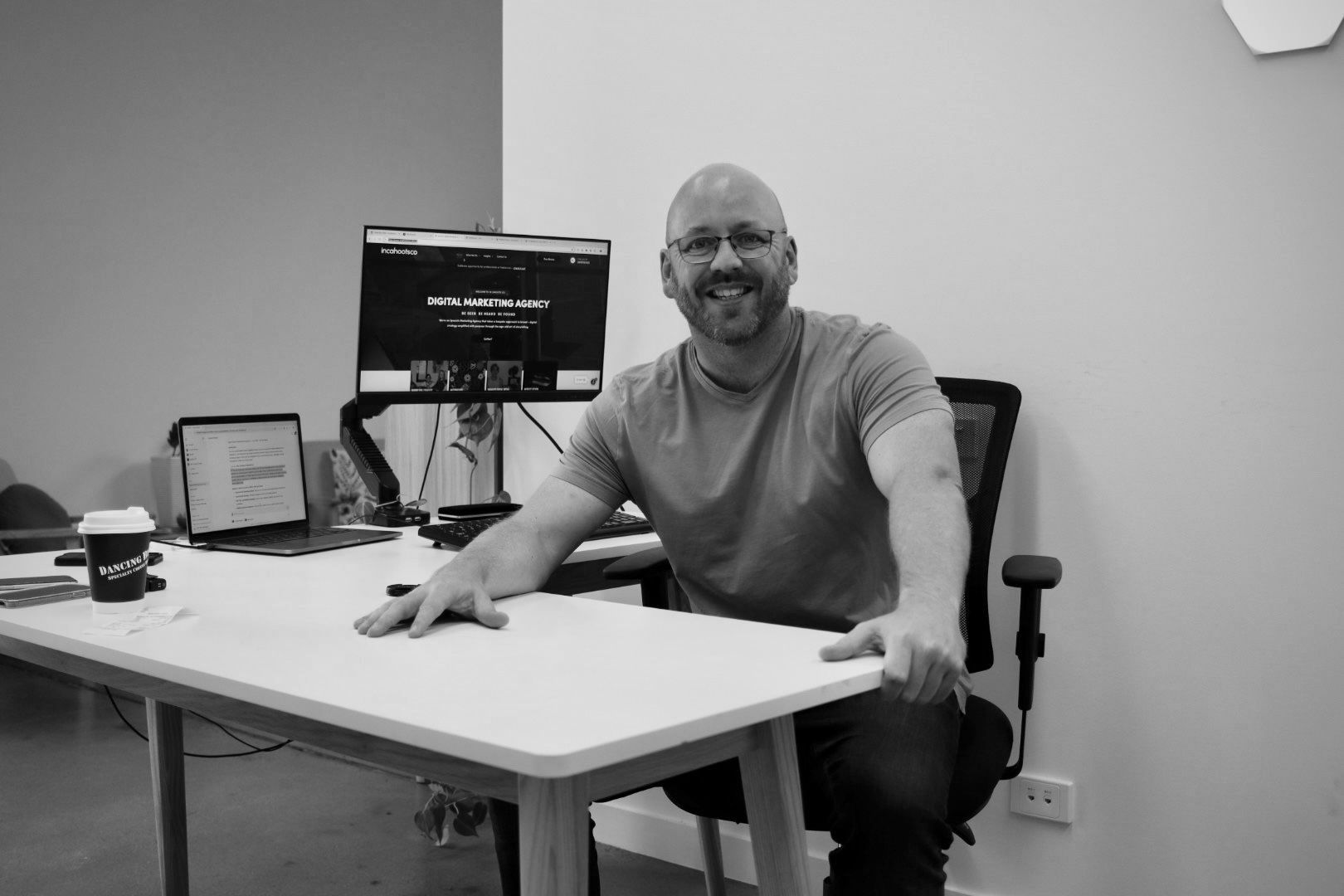 A man is sitting at a desk in front of a computer.