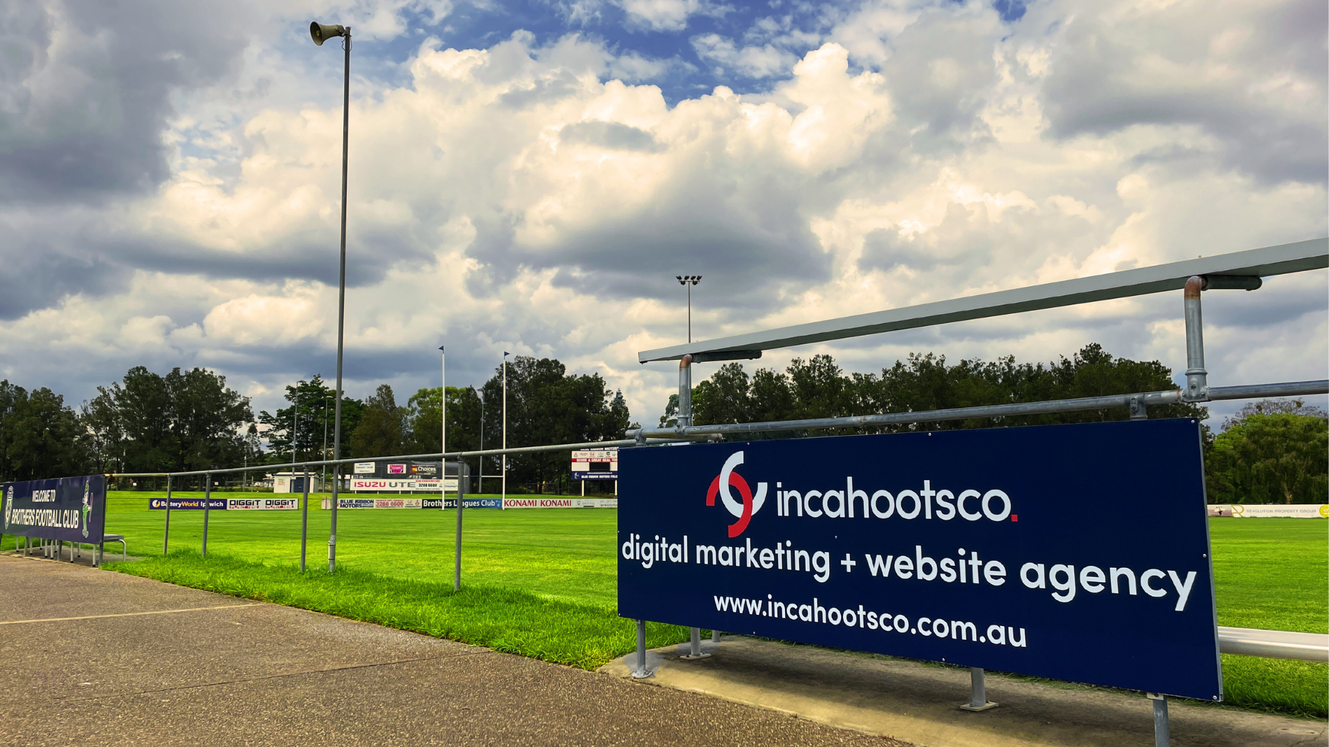 a sign for a website agency is on the side of a soccer field .