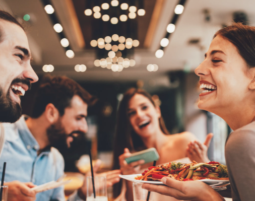 A group of people are sitting at a table eating food in a restaurant.