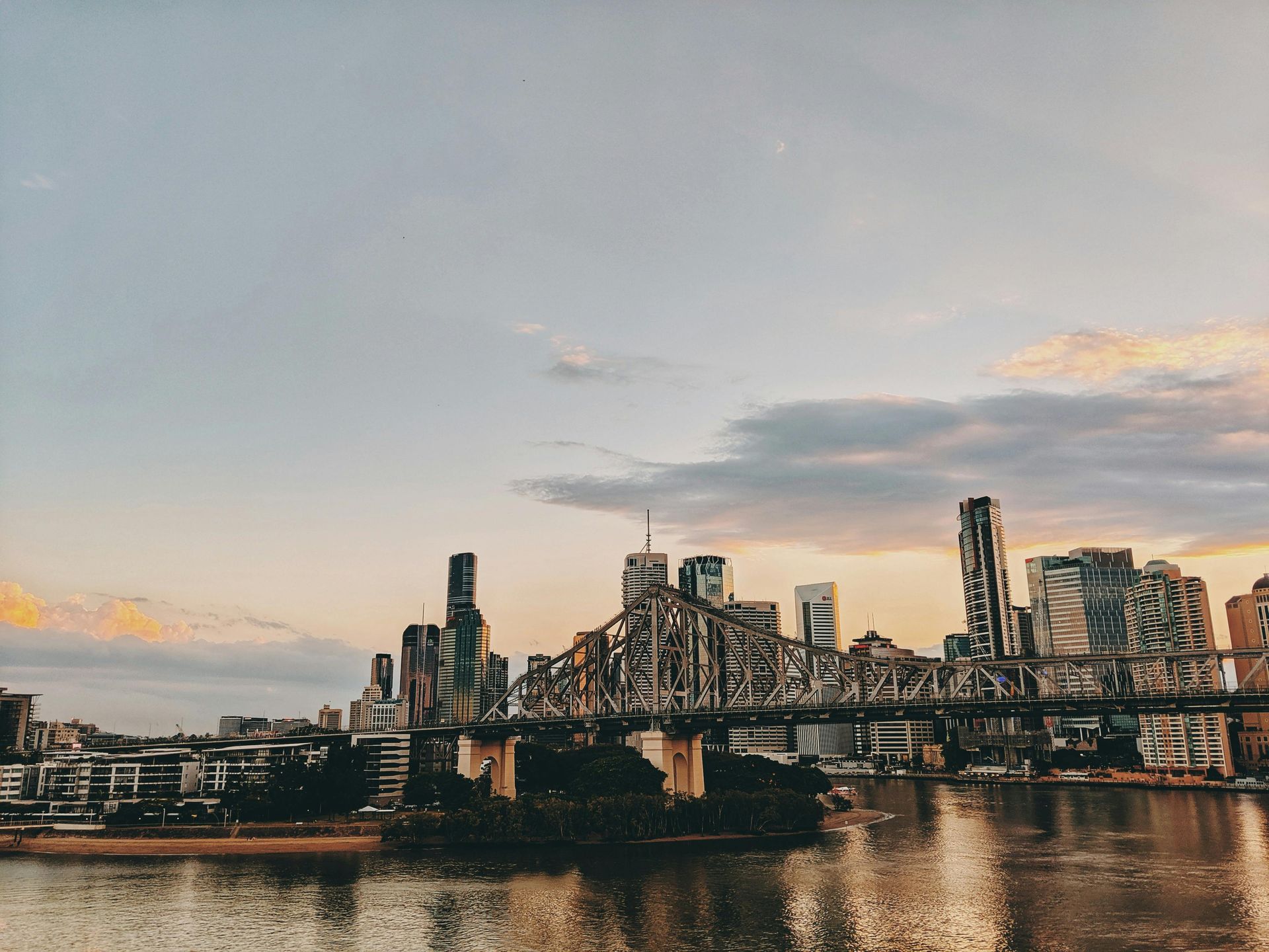 A city skyline with a bridge over a body of water in Brisbane.
