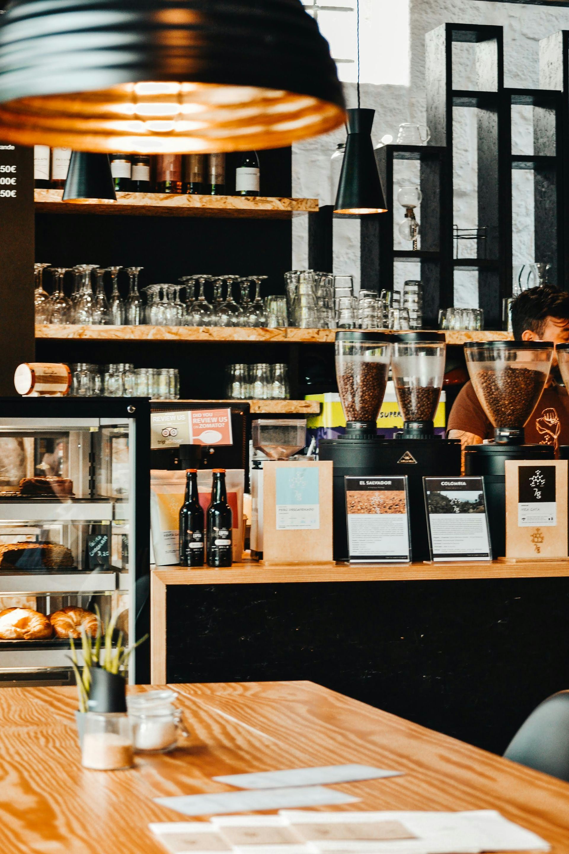 A man is standing behind a counter in a restaurant.