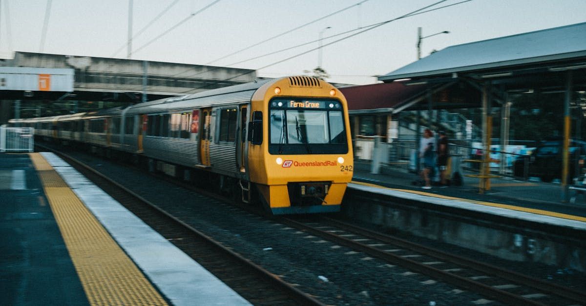 A yellow train is pulling into a train station.