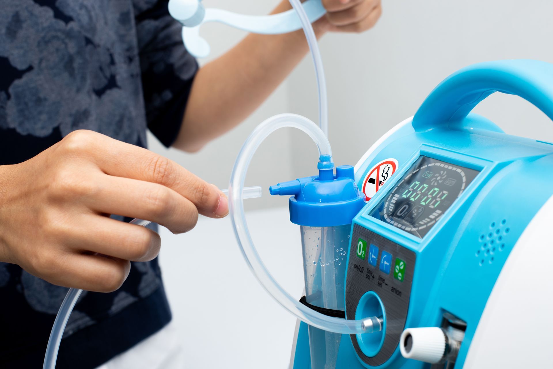 A person is using a blue and white oxygen machine.