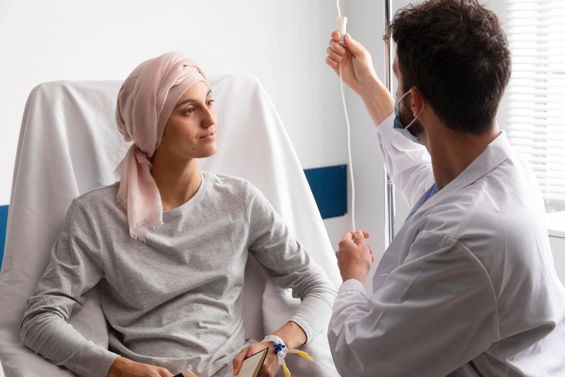 A doctor is giving an iv to a patient in a hospital bed.