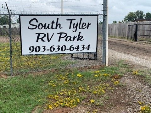 a sign for south tyler rv park is hanging on a chain link fence .