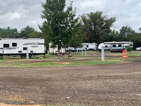 a row of rvs are parked in gravel sites