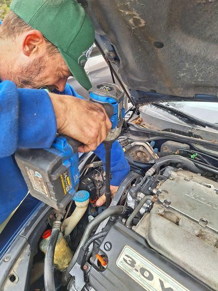 A yellow excavator is sitting on top of a pile of gravel.