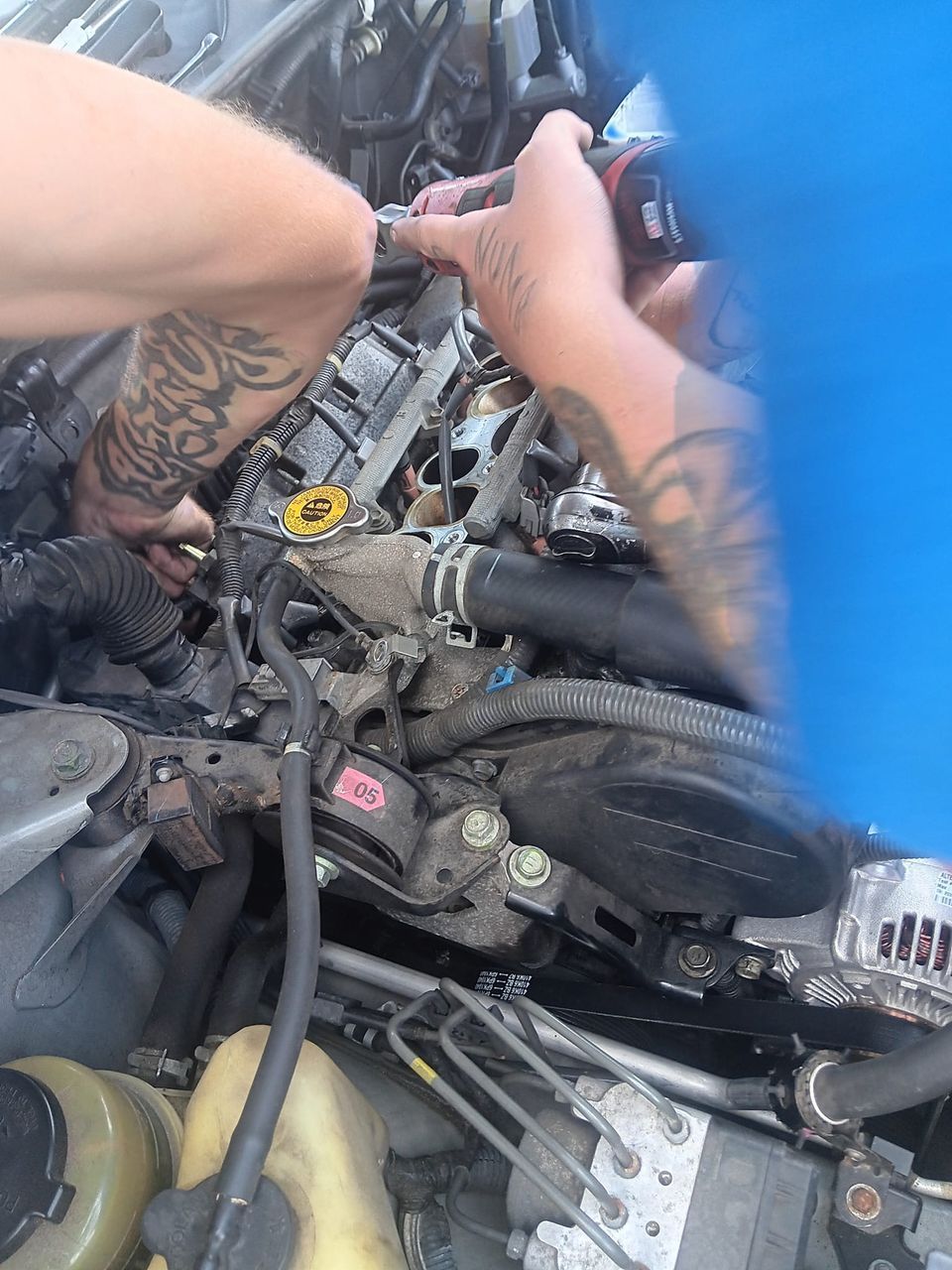 A yellow excavator is sitting on top of a pile of gravel.