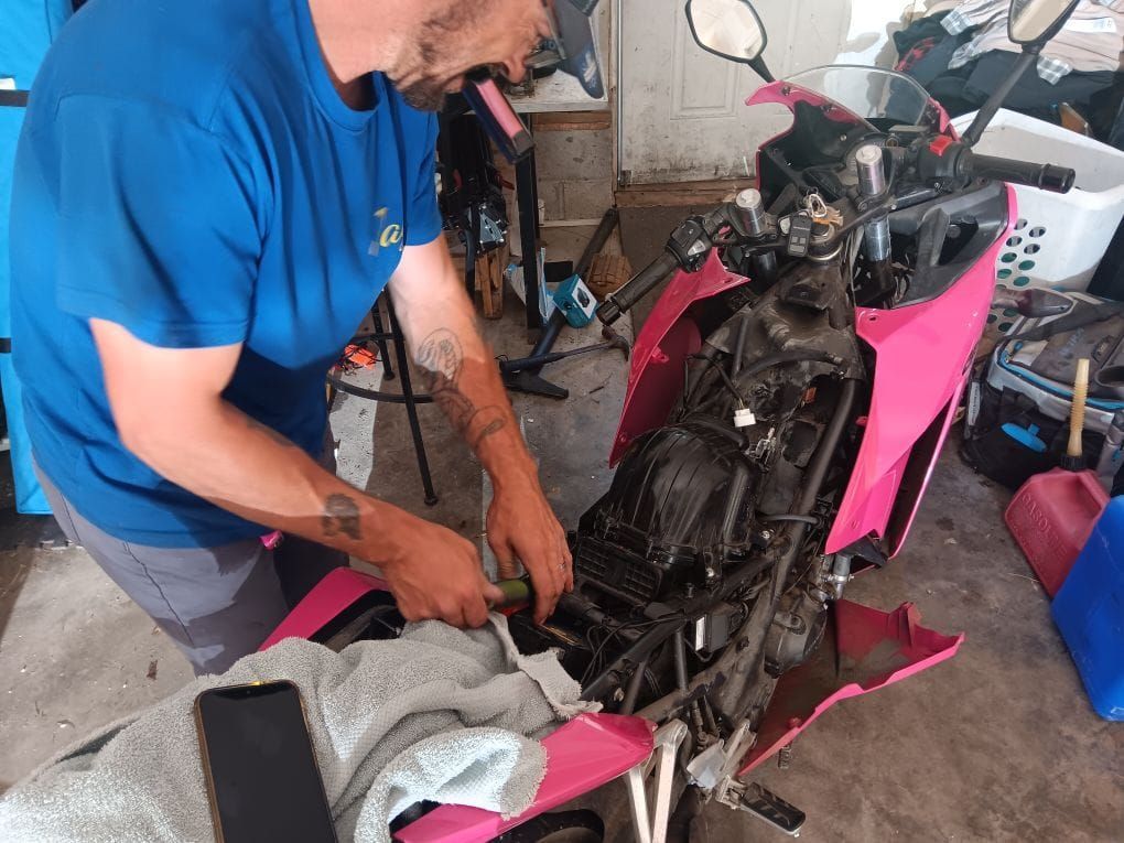 A construction worker wearing a blue hard hat is working on a roof