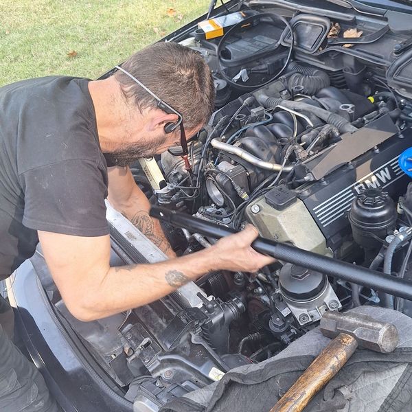 A construction worker wearing a blue hard hat is working on a roof