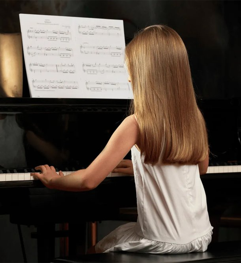 Attractive young man playing piano with dramatic lighting