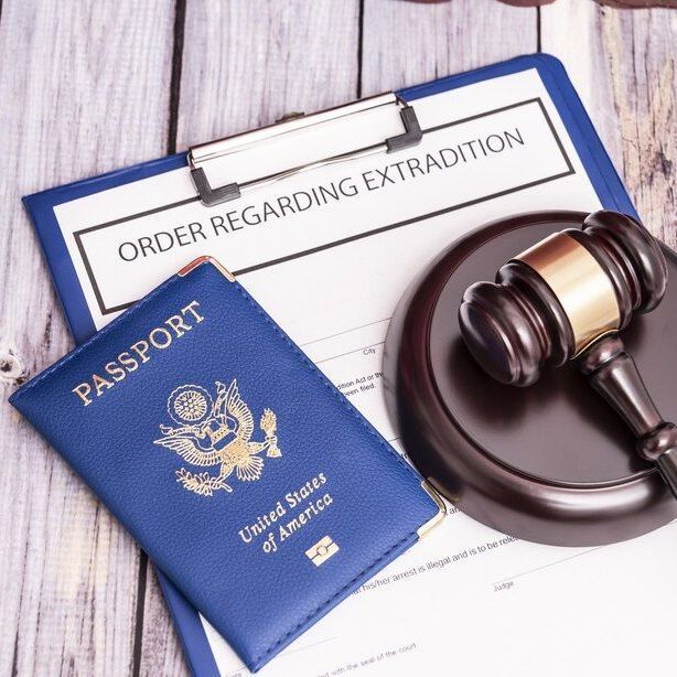 Blue passport, legal documents, and gavel on a wooden surface, suggesting an extradition order.