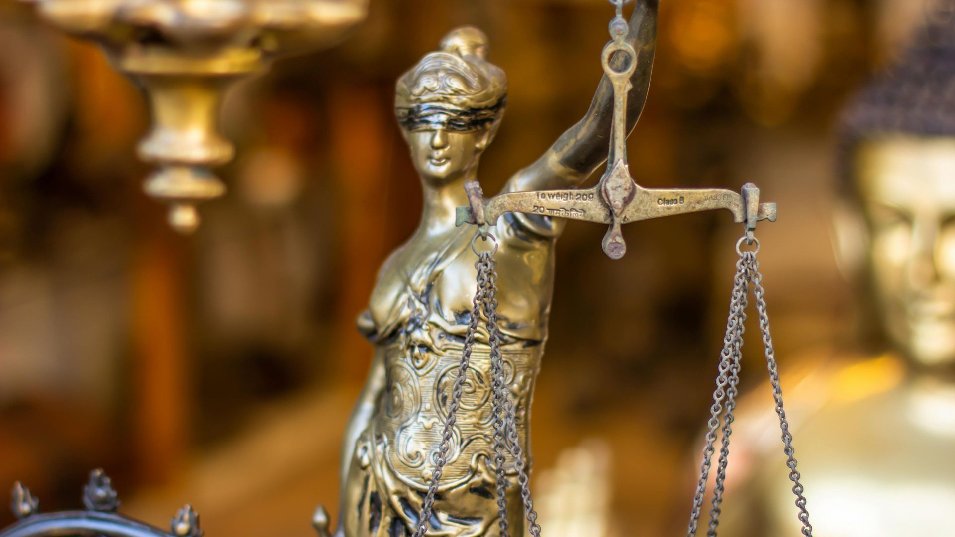 Golden statue of Lady Justice holding scales.