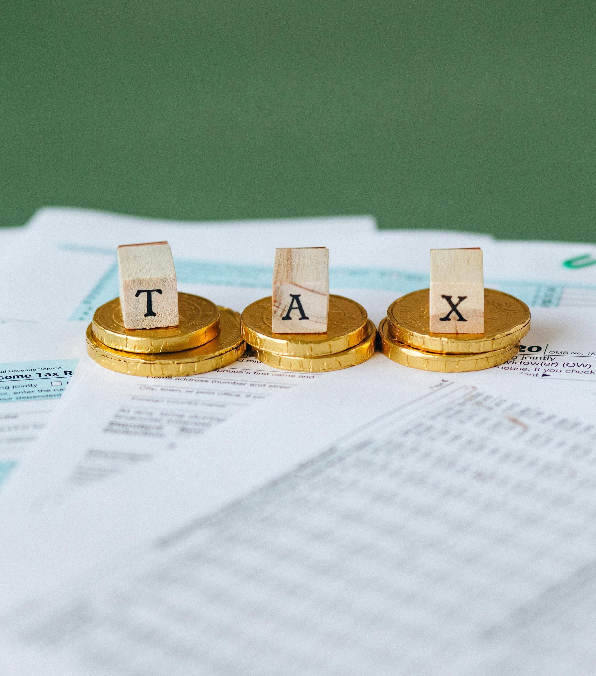 Stacked gold coins with wooden blocks spelling 
