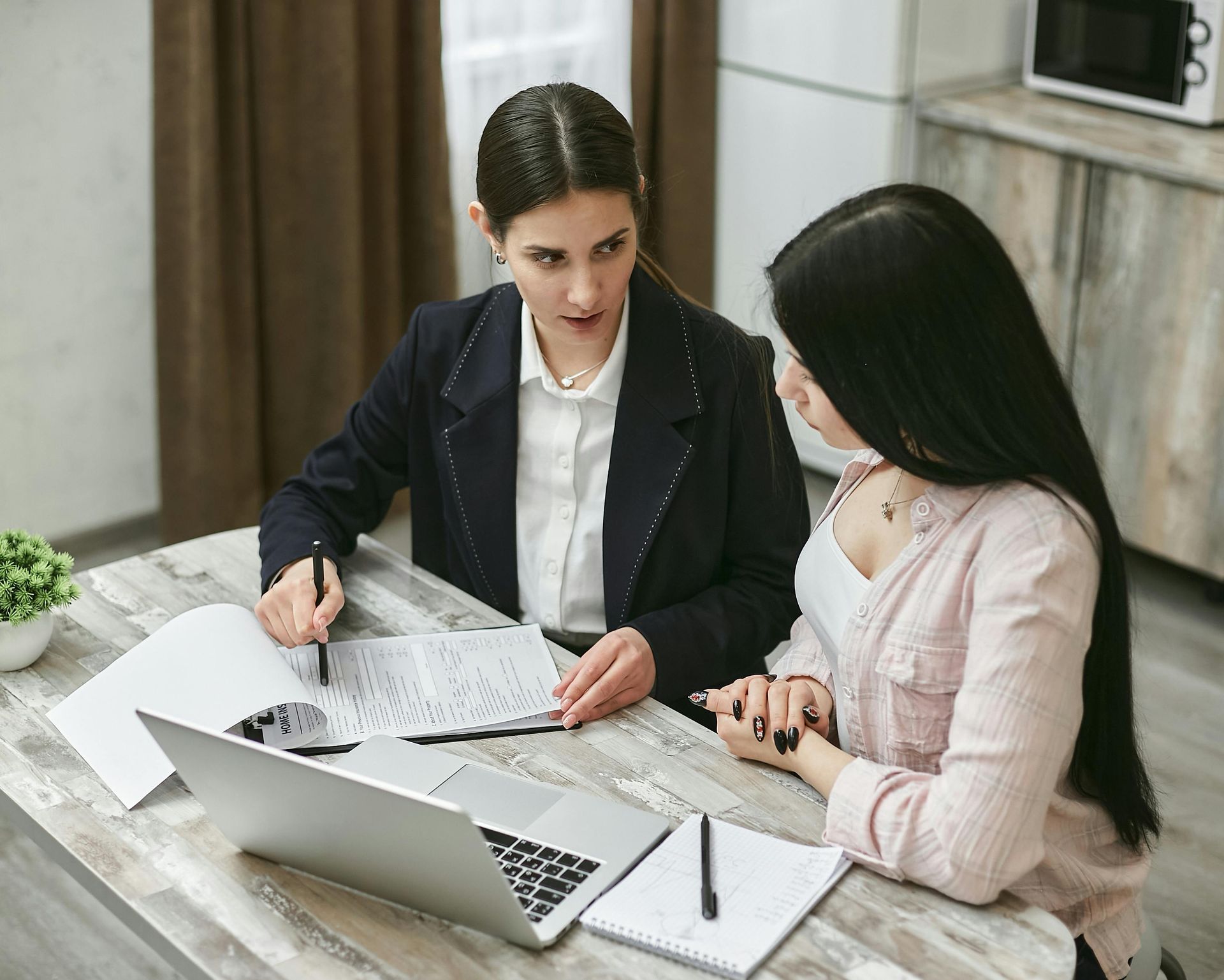 People signing a document with a lawyer; legal setting.