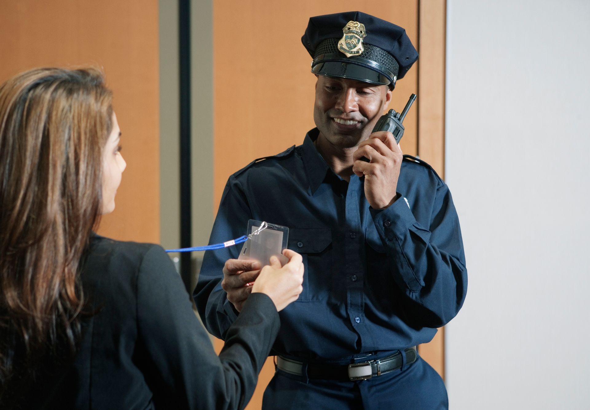 A police officer is talking on a walkie talkie to a woman.