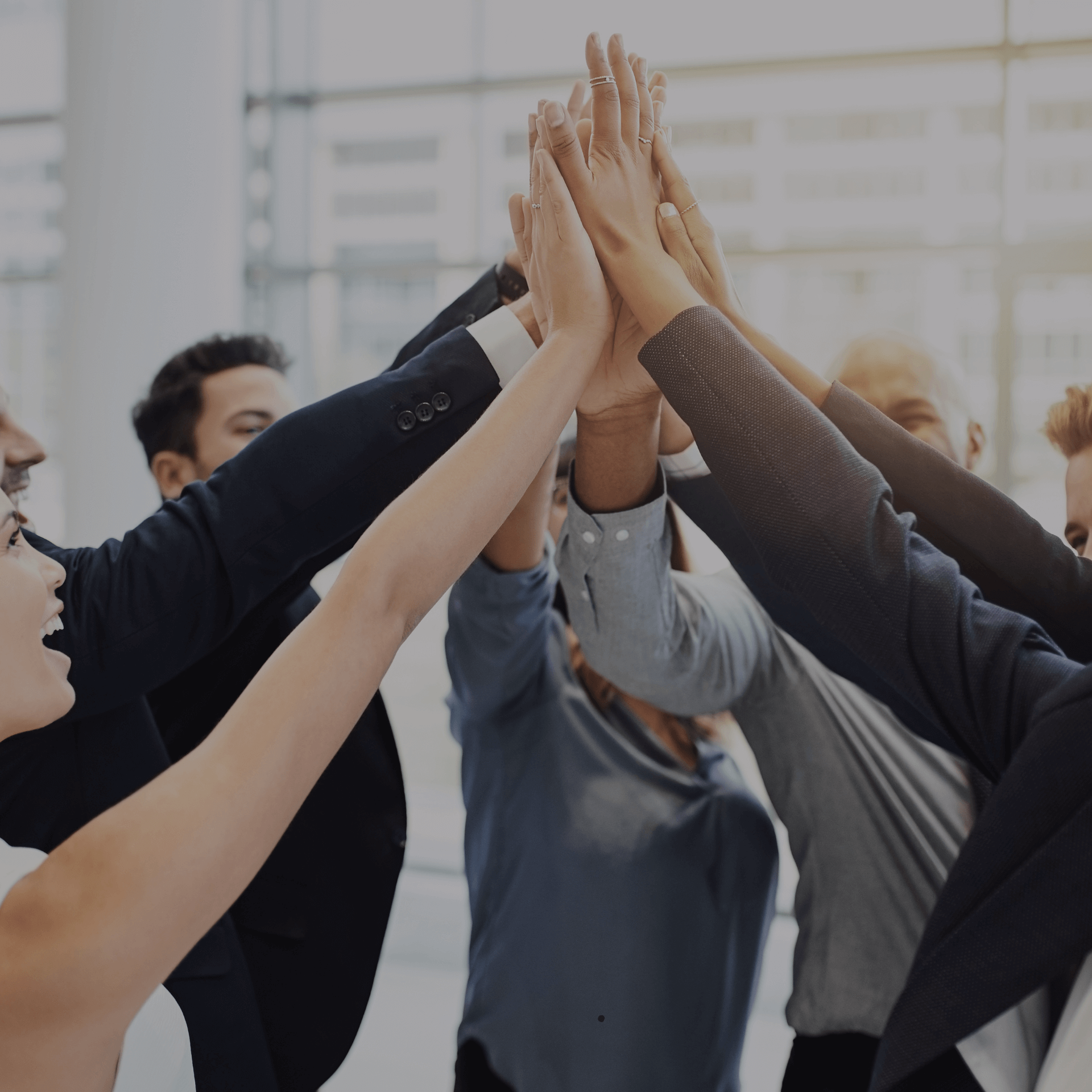 Team high-fiving in a group, symbolizing Gym Revival Group's performance-obsessed culture.
