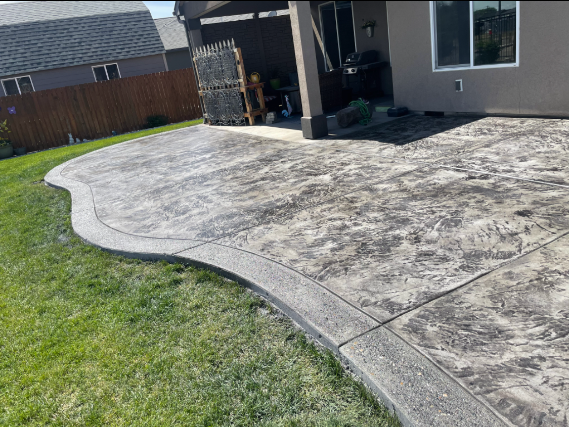 Curved stone paver walkway beside green grass in sunlight
